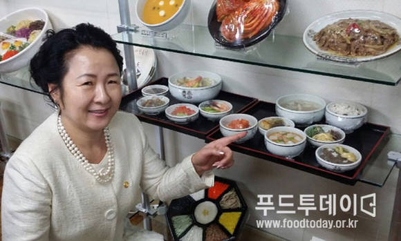 세계한식협의회 박다이아나 총회장이 한식 상차림을 가리키고있다