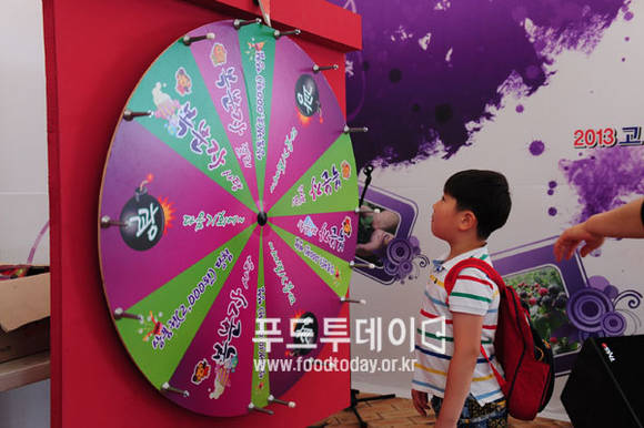 복분자 상품 룰렛 돌리기 행사에 참여하고 있는 어린이