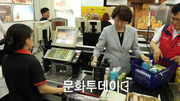 김승희 식품의약품안전처장이 계산하기 위해 물건 올려놓고 있다.