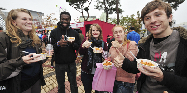 외국인 관광객들이 전주 비빔밥 축제에서 비빔밥을 먹고 있다