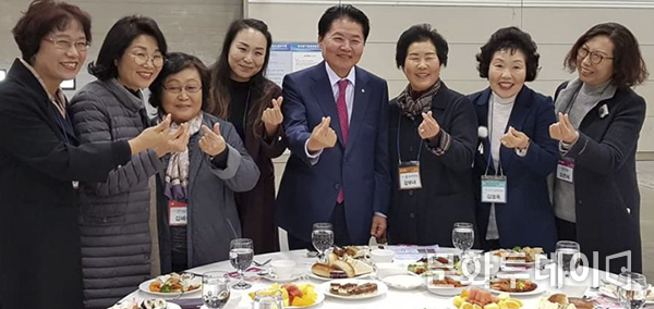 김병원 회장이 국민행복나눔 김장축제에서 관계자들과 손으로 하트를 하고 있다