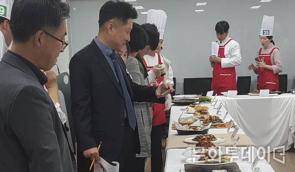심사위원들이 오리 요리 경진 대회에서 오리 요리를 심사하고 있다.