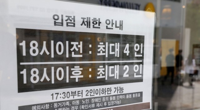 정부가 사회적 거리두기 조정안을 발표한 지난 6일 오전 서울 종로구 일대 식당에 인원 제한 안내문이 붙어있다.