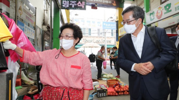 김동연부총리가 회견후 시장에들려 상인과 대화하고있다