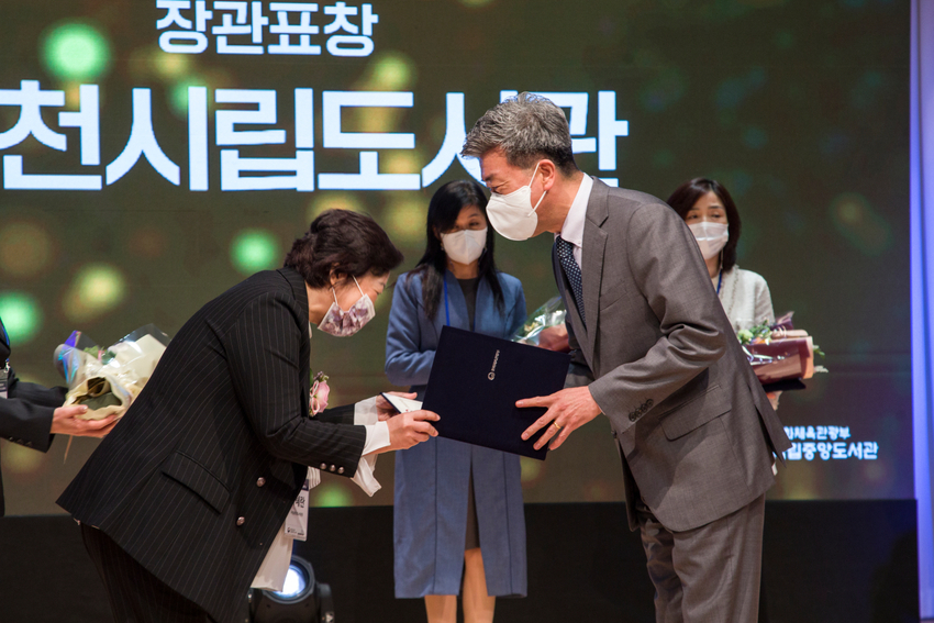 박상천(오른쪽) 제천시립도서관장이 표창장을 받으며 기뻐하고 있다.