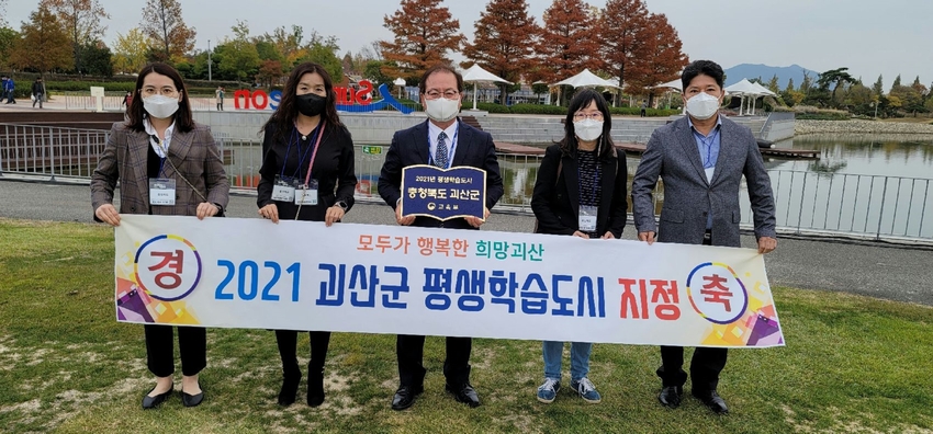 괴산군 평생학습관계자들이 '평생학습지정패'를 들고 기념촬영하고 있다.