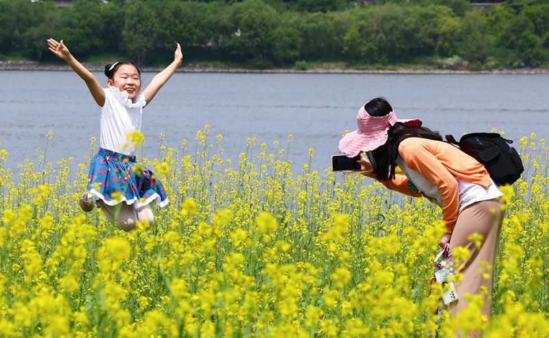 14일 서울 서초구 반포한강공원 서래섬에서 열린 2023 한강 서래섬 유채꽃 축제에서 한 어린이가 점프하며 기념사진을 찍고 있다. <br>
