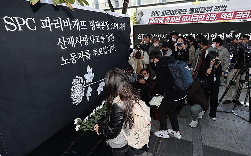 지난해 10월 20일 오후 서울 양재동 SPC 본사 앞에서 열린 평택 SPC 계열사 SPL의 제빵공장 사망 사고 희생자 서울 추모행사에서 참가자들이 헌화하고 있다. <br>

