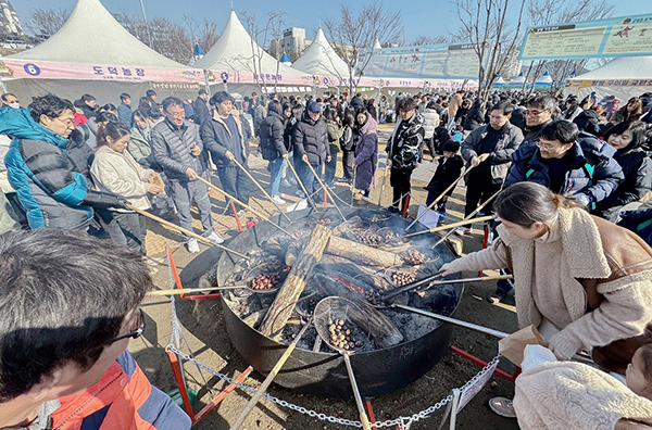  '제7회 겨울공주 군밤축제' 마지막 날인 지난 28일 축제장인 충남 공주시 금강신관공원을 찾은 관광객들이 알밤을 뜰망에 담아 장작불이 이글거리는 대형 화로에 굽고 있다. <br>
