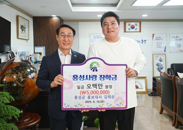 <strong>홍성사랑 장학금 전달하는 김태균(오른쪽) 해설위원과 이용록 홍성군수</strong><br>
