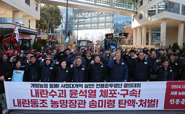 트랙터와 트럭 수십 대를 몰고 상경 행진 중인 전국농민회총연맹 전봉준 투쟁단 소속 농민들이 19일 오후 정부세종청사 농림축산식품부 앞에서 "윤석열 체포ㆍ구속 및 송미령 장관 탄핵ㆍ처벌"을 외치고 있다. <br>
