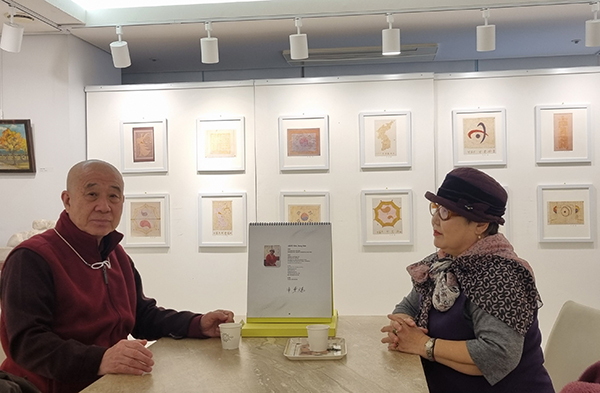 보검스님이 한국미술진흥원에서 12월력(달력) 그림 전시 중인 ‘우주 기’ 작가 청룡 신동희 화가와 담소를 나누고 있다.<br>

