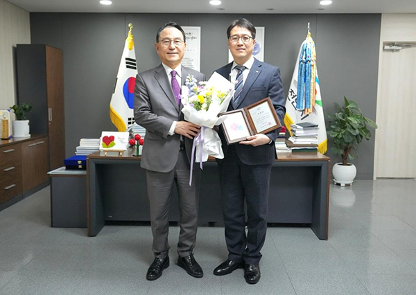  삼환기업 유창훈 대표이사(오른쪽)가 지난 4일 충남 천안시청 7층 시장 집무실에서 시정 발전 유공 시민 표창패와 꽃다발을 들고 박상돈 천안시장과 기념촬영을 하고 있다. <br>

