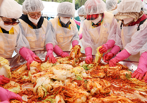 대한적십자사 충북지사 봉사회원들이 29일 청주시 흥덕구 적십자 충북지사 앞마당에서 열린 '사랑 더하기, 김장 나누기' 행사에 참여해 김치를 담그고 있다.<br>
 